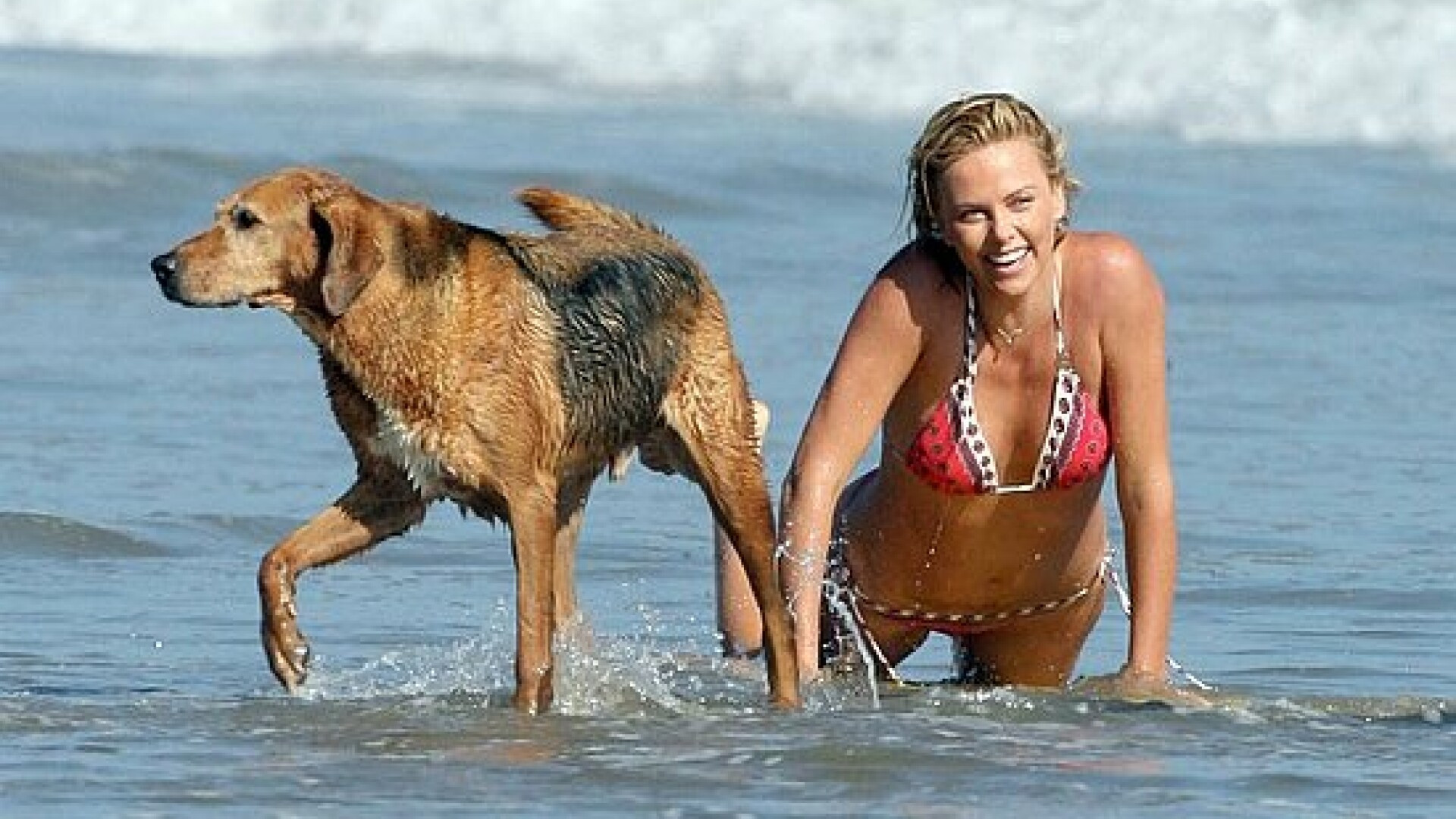 Charlize Theron isi face de cap pe plaja