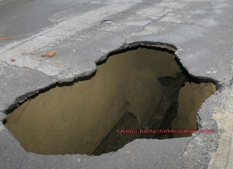 Curat ghinion! A fost inghitit cu masina cu tot de o groapa de pe sosea!