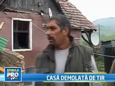 Un TIR incarcat de butelii goale a intrat intr-o casa
