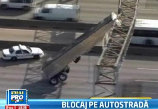 Haos pe o autostrada din Statele Unite. Remorca unui TIR a ramas suspendata de o pasarela
