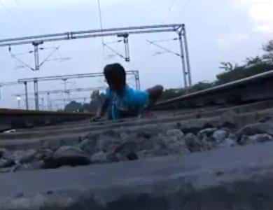 Moartea, luata in ras. Sta intins pe sine in timp ce trenul trece peste el. VIDEO sinonim cu nebunia