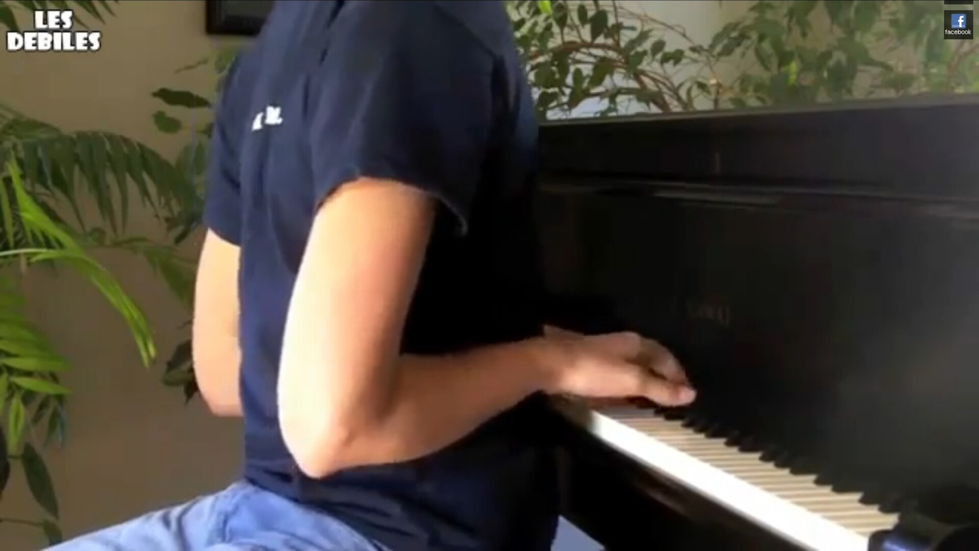 Cu spatele spre clape. Canta la pian cu mainile pe dos. VIDEO