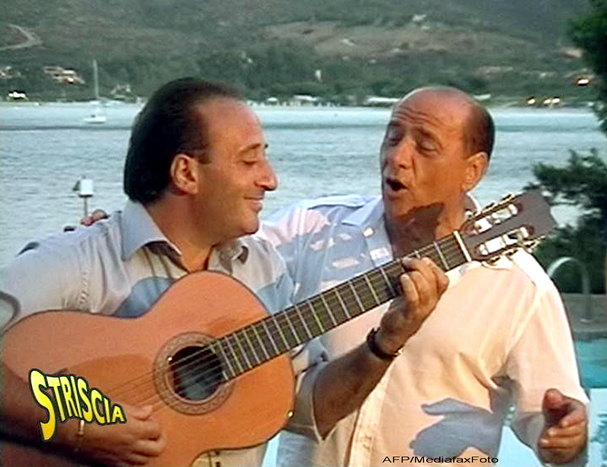 Silvio Berlusconi canta cu cu compozitorul italian Mariano Apicella in timpul unei petreceri private, pe 22 septembrie 2003