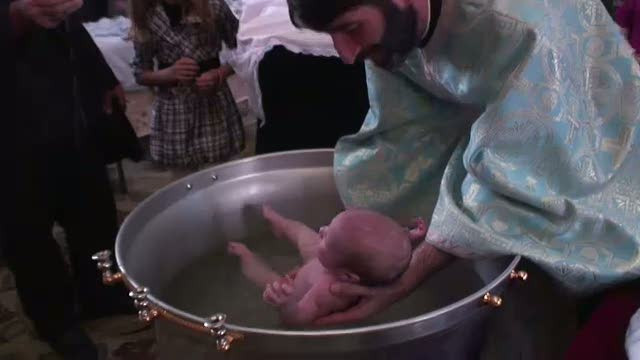 Preotul care a fost aproape sa inece o fetita in cristelnita si-a schimbat metoda de a boteza