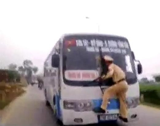 Imaginile zilei. Un politist se agata de stergatoarele unui autobuz pentru a opri un sofer nebun