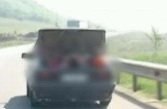 IMAGINI socante. Un sofer face viraje periculoase, cu patru copii in portbagajul deschis al masinii