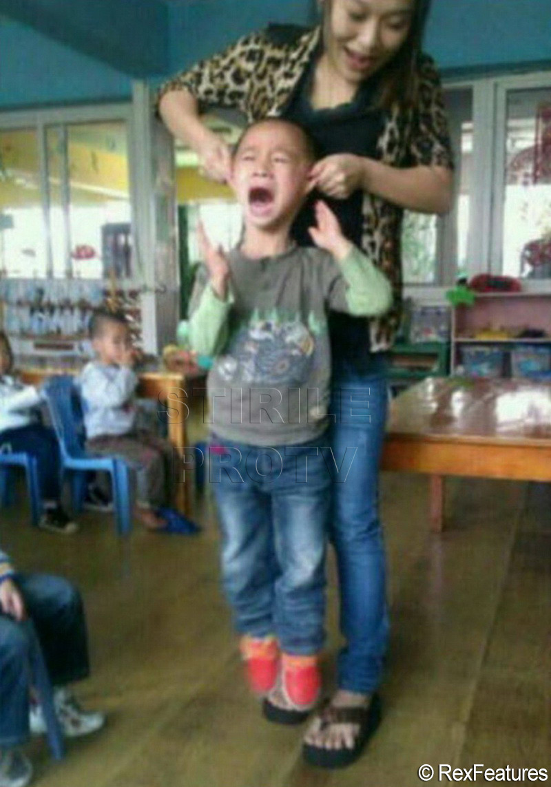 O educatoare isi ridica elevul de urechi in aer. Imaginile cu care s-a laudat apoi pe internet