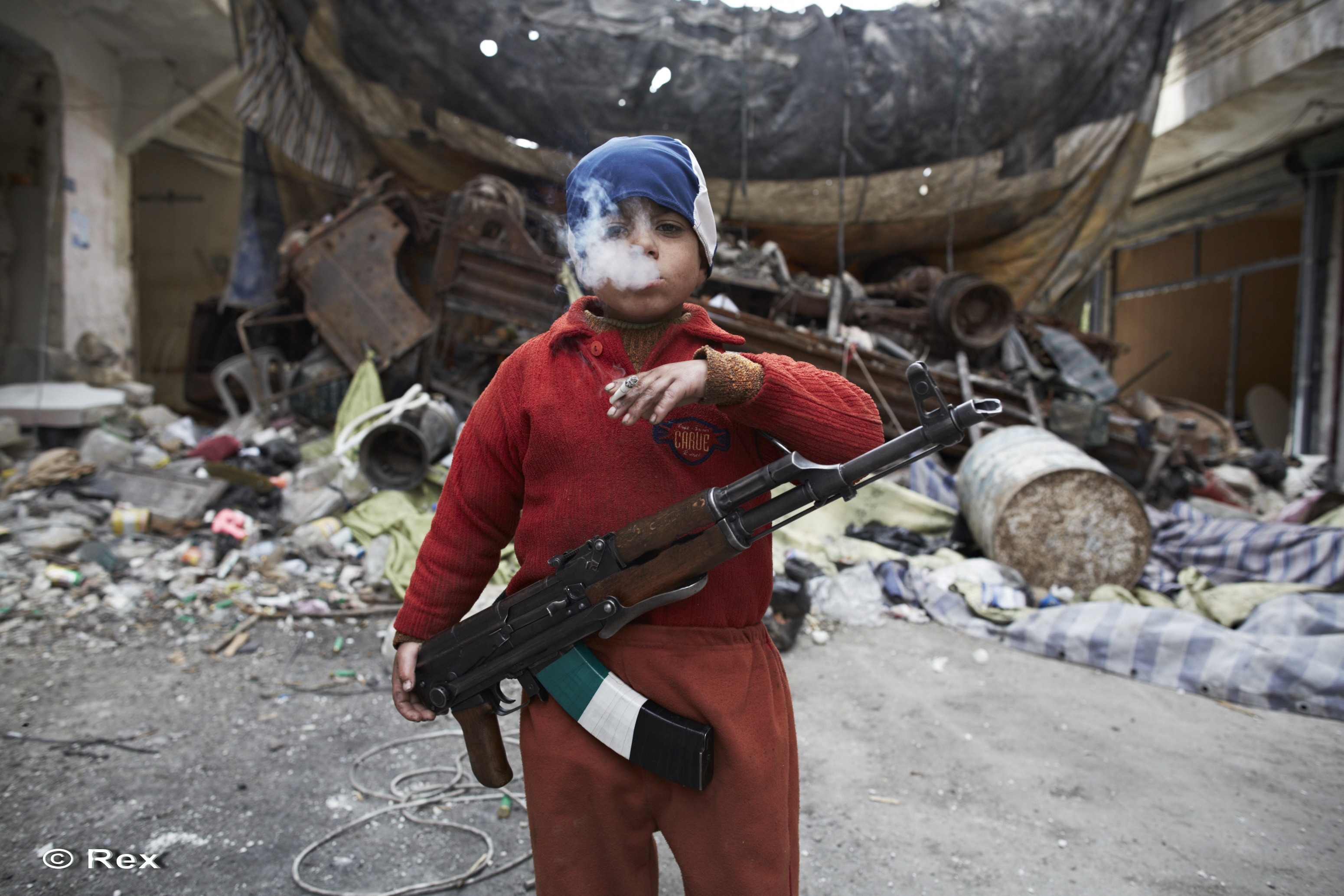 Poza care a intristat pe toata lumea: cum arata un copil din Siria cu o arma si o tigara in mana