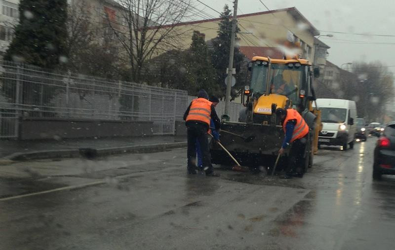 Vremea rea nu ii tine pe muncitori in loc. In timp ce afara era lapovita, ei astupau gropile. FOTO