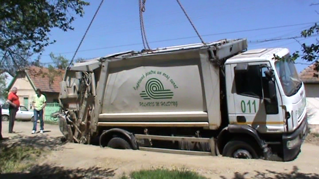 Drum surpat intr-un cartier din Arad. O masina de ridicat gunoiul a ramas blocata intr-o groapa