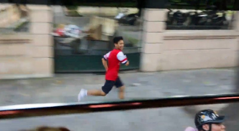 fan Arsenal alearga pe langa autocar