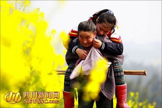 Gest induiosator in China. O femeie isi duce nepoata, care e bolnava, la scoala in fiecare zi carand-o in spate. FOTO