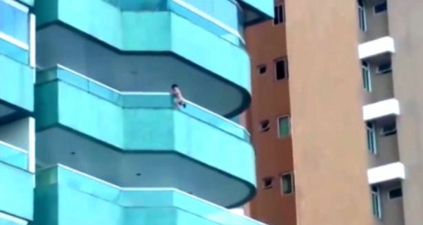 Un copil de 3 ani se tine doar cu o mana de balustrada balconului, la 15 metri inaltime. Ce fac parintii in acest timp. VIDEO