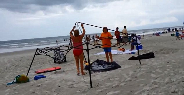 Moment amuzant pe o plaja din SUA. Doua femei sunt prinse in timp ce incearca sa fure un baldachin