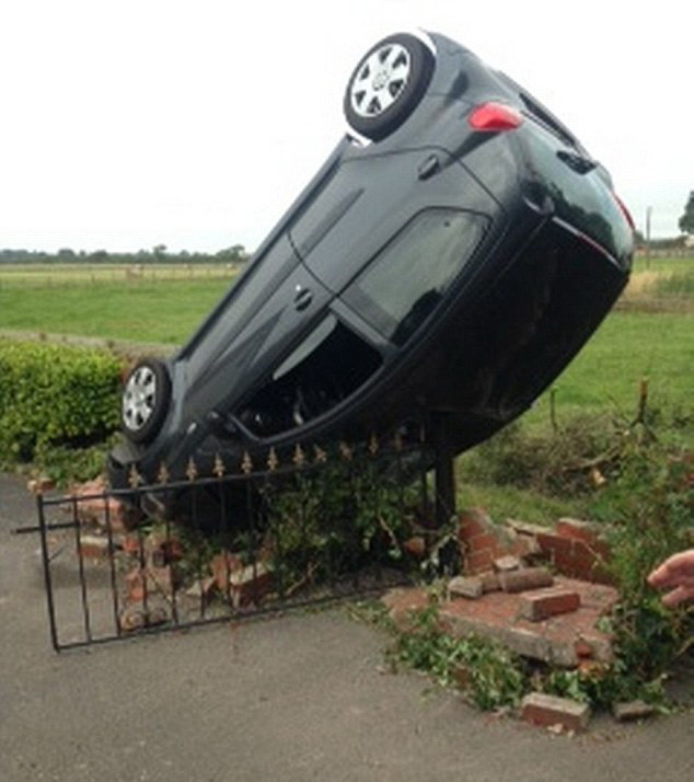 O masina a ramas in pozitie verticala in urma unui accident, dupa ce soferita a trecut cu roata peste o groapa. FOTO