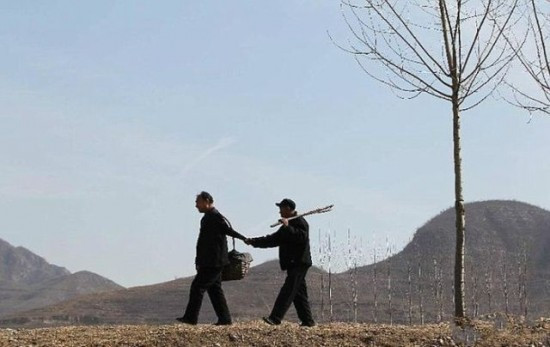 Barbatii cu dizabilitati din China care au plantat 10.000 de copaci. "El este mana mea, iar eu sunt ochii lui"