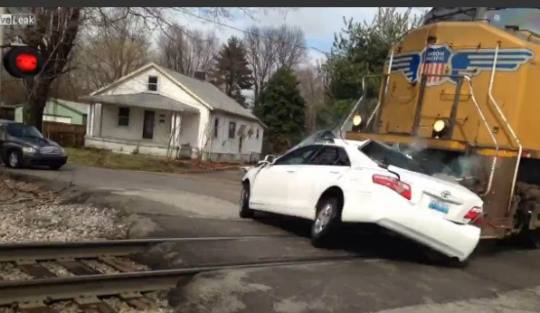 Imagini SOCANTE. Momentul in care o masina este lovita de un tren si impinsa un kilometru si jumatate pe calea ferata