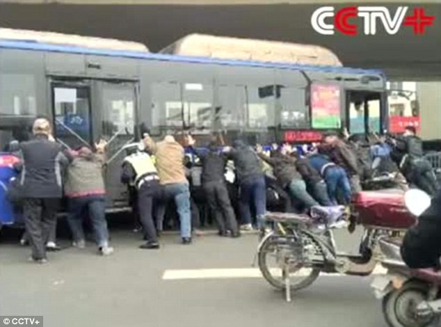 Un barbat din China a fost scos de sub rotile unui autobuz de catre pasageri si trecatori. VIDEO