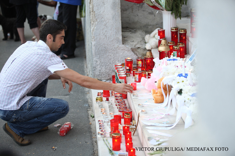 barbat care aprinde o lumanare in memoria victimelor de la incendiul de la MAternitatea Giulesti 2010