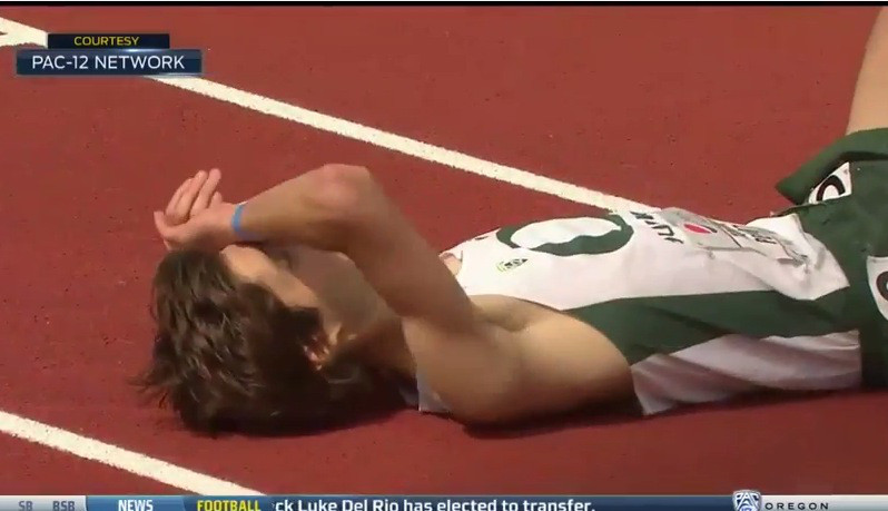 Un atlet isi ridica mainile catre public, in semn de victorie, fiind gata sa termine cursa. Toata lumea rade acum de el