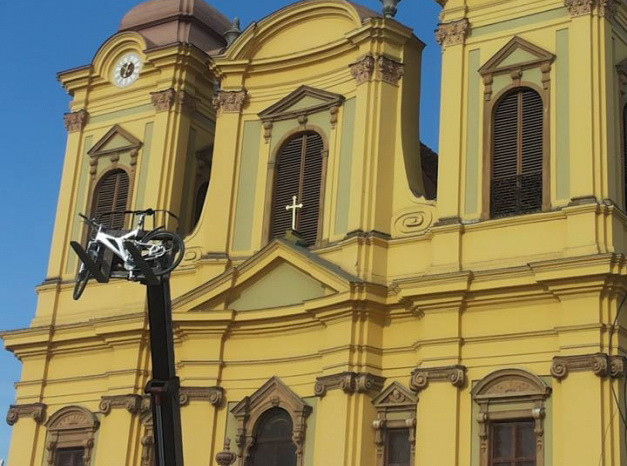 Si-a urcat bicicleta pe macara de frica hotilor. Ideea unui muncitor din Timisoara care a uimit trecatorii