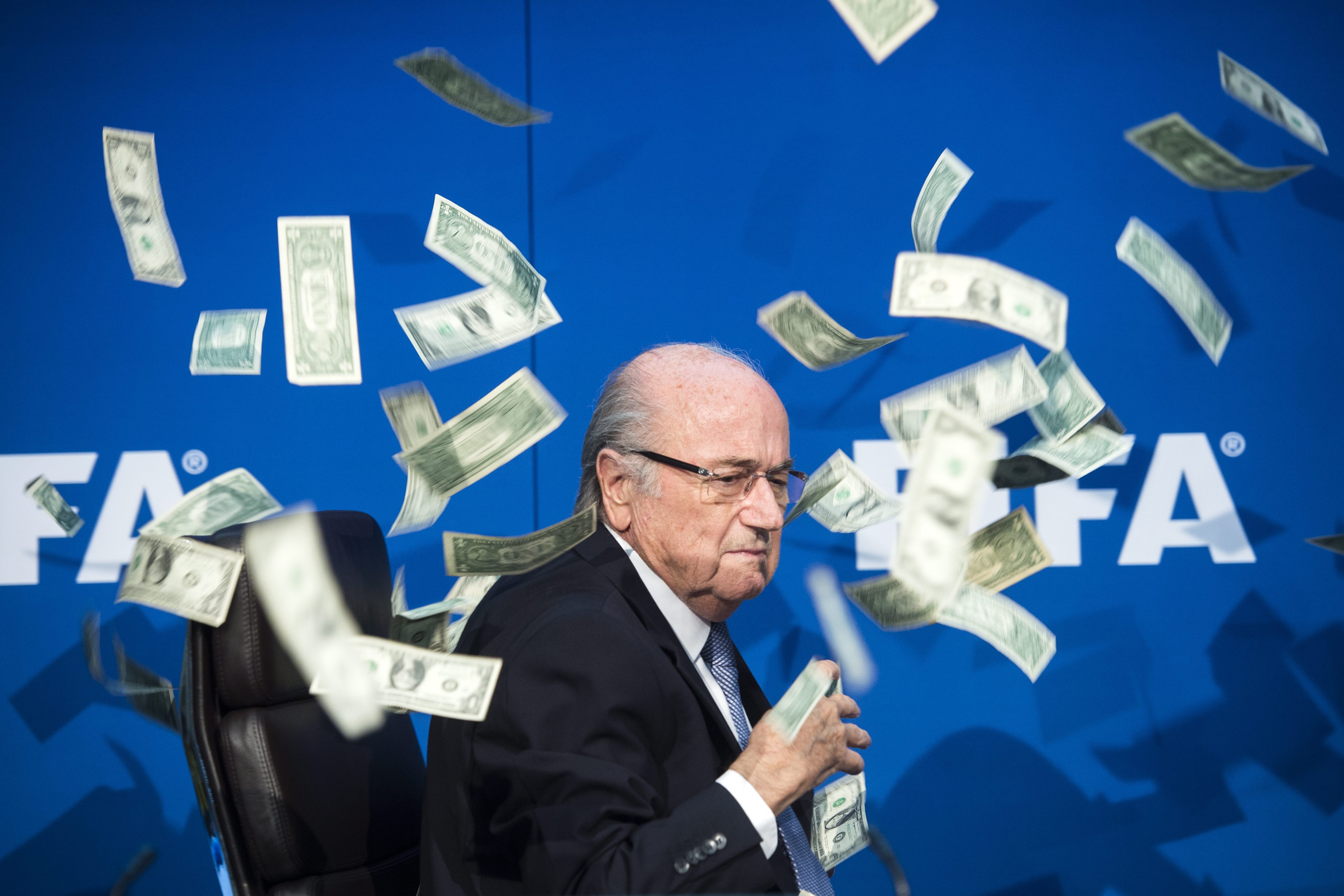 A plouat cu bani peste Sepp Blatter in timpul unei conferinte de presa. Farsa unui comediant britanic l-a scos din sarite