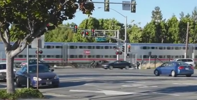 Un politist a salvat in ultima clipa un barbat blocat cu masina pe calea ferata. Soferul a fost tarat inainte sa vina trenul