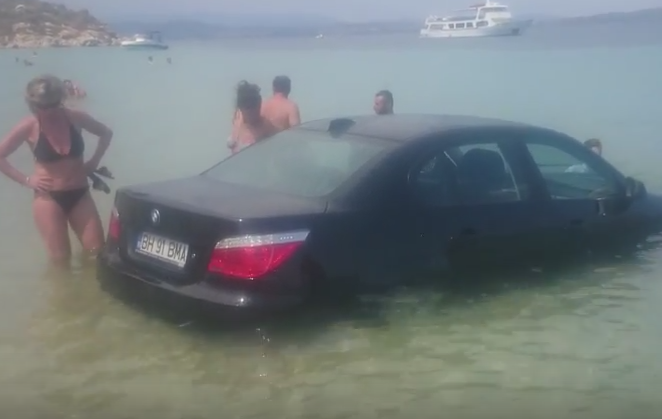 Un roman cu BMW a intrat cu masina in mare si nu a mai putut iesi. Turistii s-au ingramadit sa vada grozavia. VIDEO
