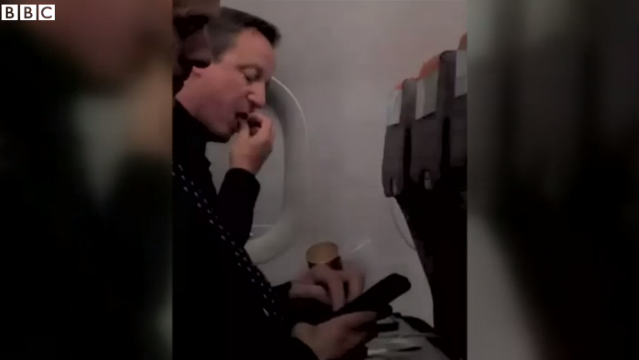 David Cameron, filmat intr-un avion low-cost, la clasa Economy. "E la doua scaune de mine si mananca Pringles"