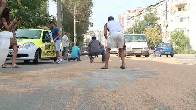 Trei tone de grau au cazut dintr-un TIR pe o sosea din Iasi. Localnicii au adus farase si s-au apucat sa curete strada
