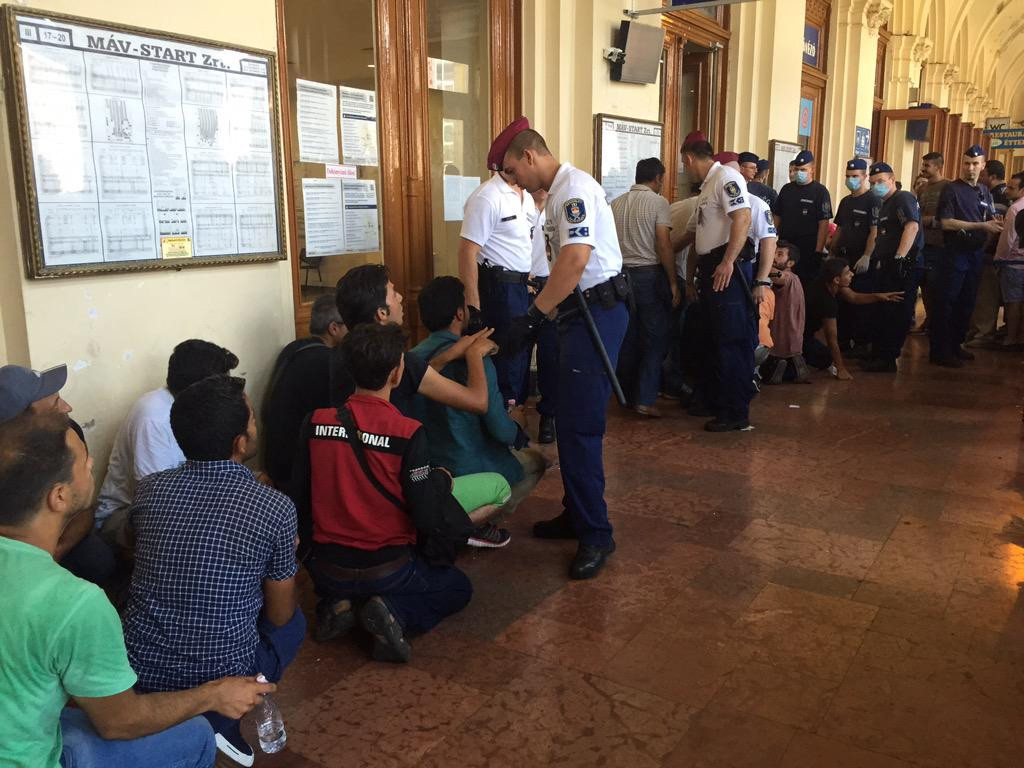 Fotografia zilei: Refugiati ingenunchiati in gara din Budapesta