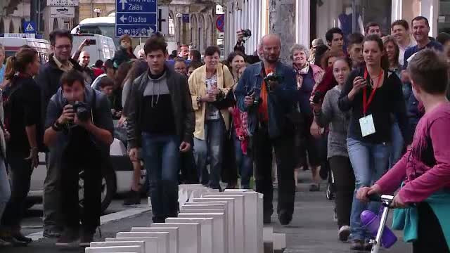 3000 de piese de domino s-au intins pe 1,2 kilometri, in centrul Clujului. Sute de oameni au alergat dupa piesele in cadere