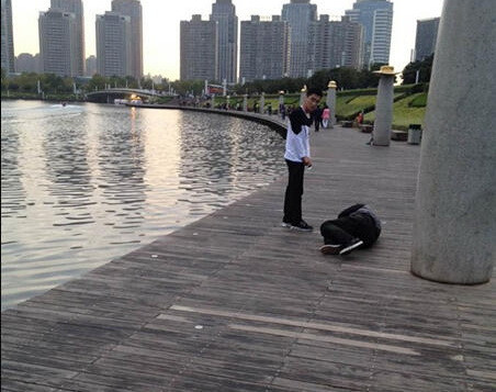 Turul unui lac in genunchi, pedeapsa primita de angajatii unei companii din China. Cu ce gresisera acestia. FOTO