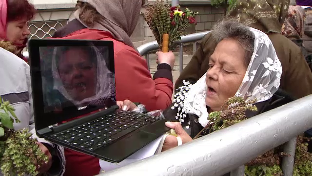 Scene ireale la pelerinajul de la Iasi. O femeie se pozeaza sarutand moastele Sf. Parascheva cu laptopul: "Hai, ma, mergi!"