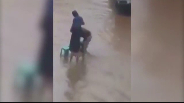 Cavaler in cele mai grele conditii. Modul inedit prin care un indian si-a ajutat sotia sa traverseze o strada inundata