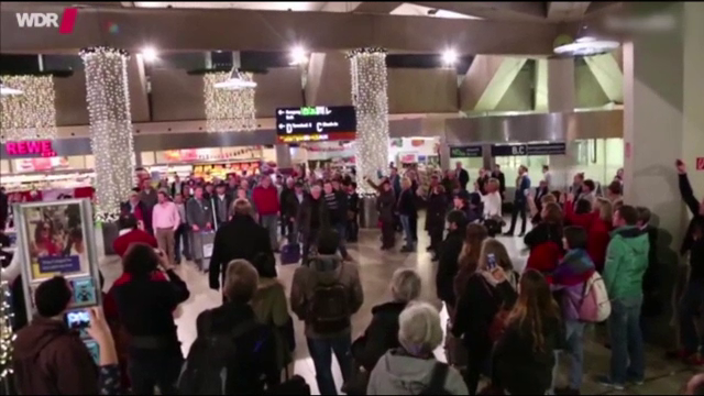 Flashmob cu colinde pe aeroportul din Koln. Reprezentatia, demna de o scena de opera