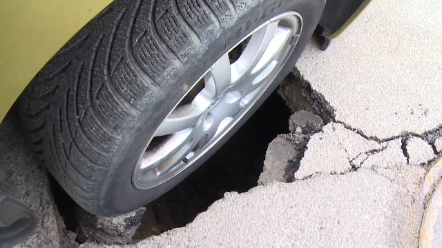 Reactia unui sofer din Pitesti, dupa ce o groapa formata in fata locului de parcare i-a "inghitit" roata din fata a masinii