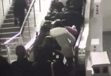 Momentul in care o scara rulanta isi schimba brusc, directia de mers, in China. Oamenii au cazut gramada peste altii