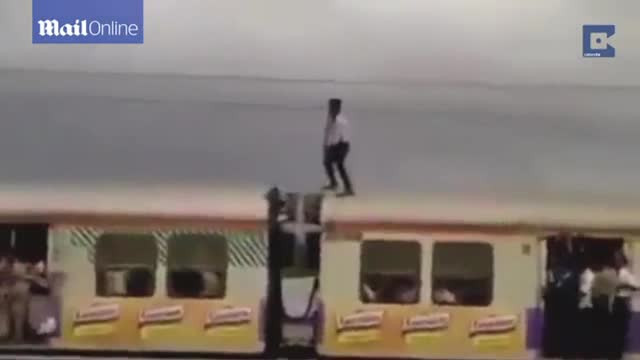 Cascadorie riscanta in India. Un barbat a facut echilibristica pe un tren in miscare, la cativa centimetri de cabluri