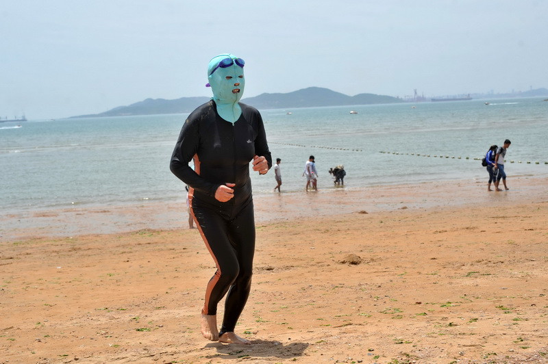 Fenomenul care devine tot mai popular in China. Motivul pentru care tot mai multi chinezii poarta cagula pe fata, la plaja