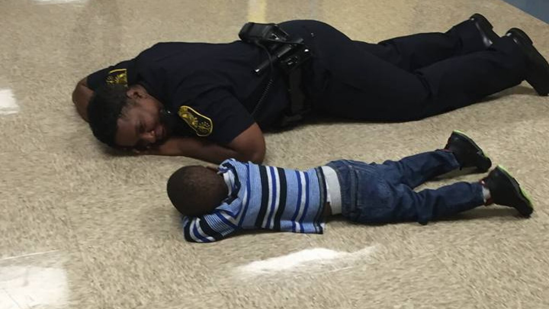 Momentul in care o politista consoleaza un baietel trist, culcat la podea. Ce s-a intamplat dupa cateva minute