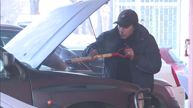 Imagini filmate in Capitala. Doi barbati incearca sa stinga cu zapada focul izbucnit sub capota unei masini