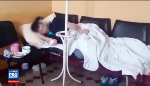 Pacient cu perfuzie, obligat sa stea pe un pat improvizat din scaune la spitalul din Medias. Explicatiile oferite de medici