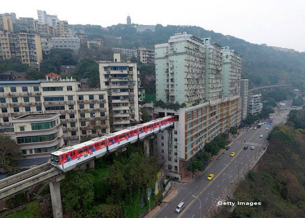 Un bloc turn din China este traversat chiar in mijloc de linia ferata. Ce spun oamenii care stau in cladire