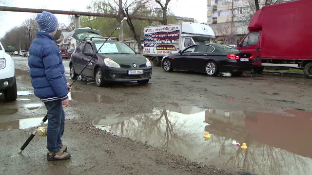 Protest inedit pe un drum plin de cratere de langa Iasi. Un tanar a venit cu lanseta ca sa pescuiasca in gropi