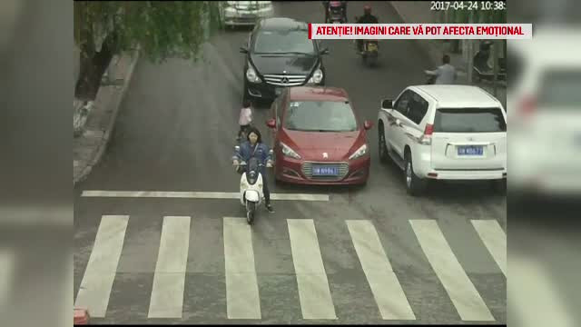 O fetita de doi ani din China a scapat cu viata dupa ce au trecut peste ea 2 masini. Cum a ajuns copila in mijlocul soselei