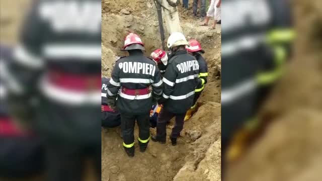 Doi bărbați, acoperiți de un mal de pământ. Unul dintre ei a murit