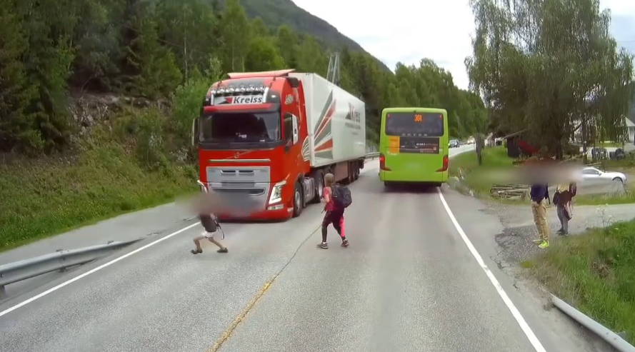Un băiat care traversează strada în fugă, la un pas să fie lovit de un TIR