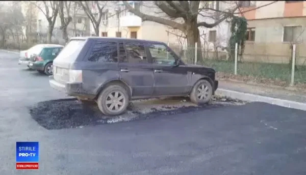 Muncitorii au asfaltat în jurul unei maşini, în Craiova. ”E mai rău ca în Las Fierbinți”