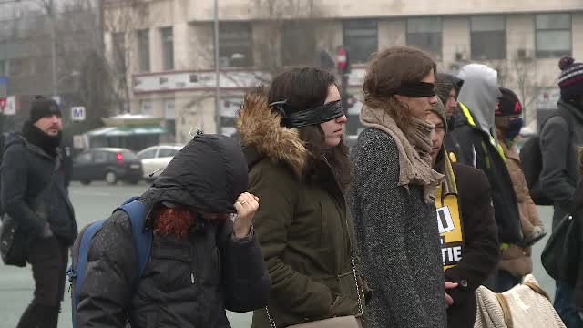 Protest mut în Piața Victoriei. Flash mob cu oameni legați la ochi